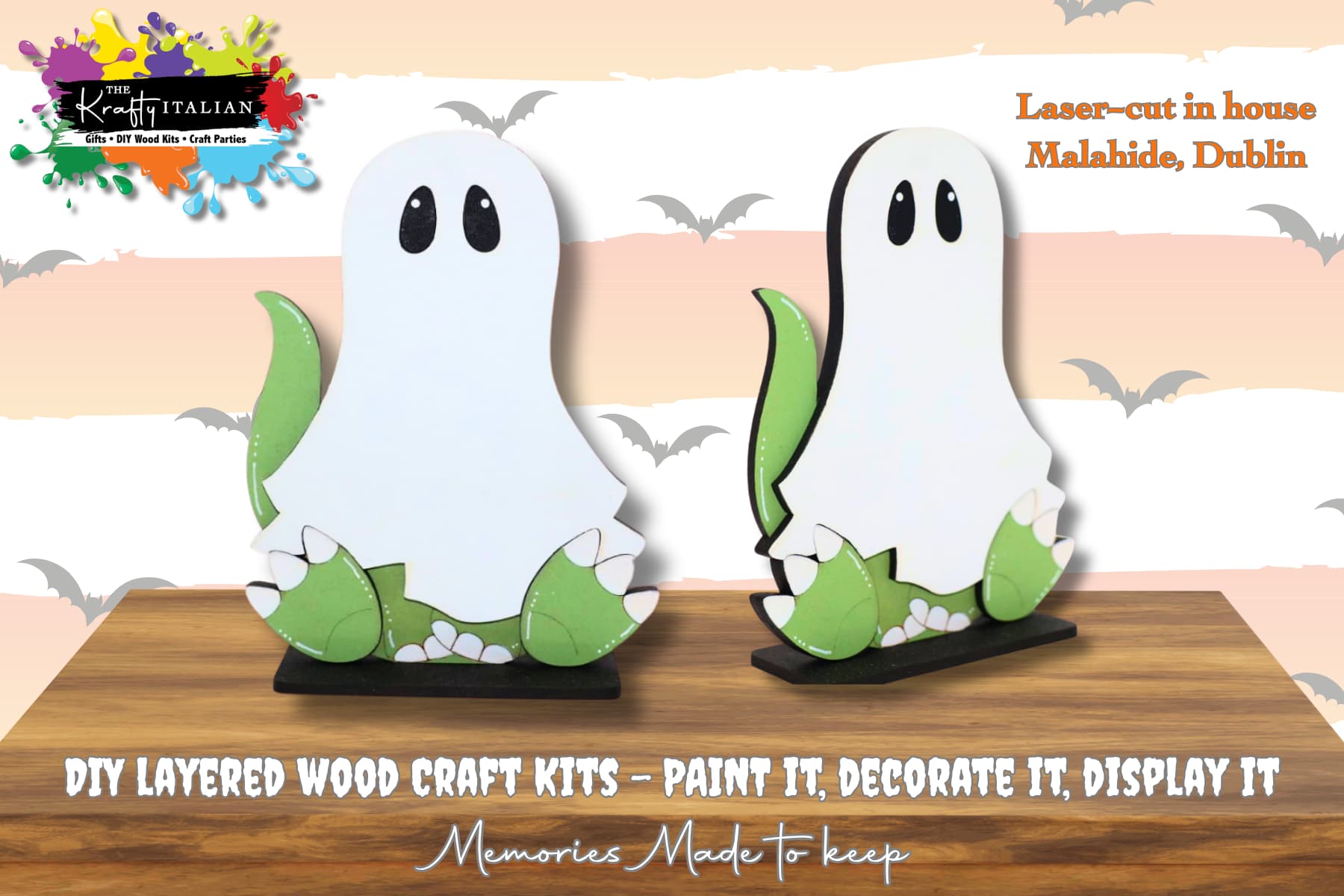 Two white and green layered wooden ghost craft kits are displayed on stands, promoting a DIY paint and decorate set. Text indicates they are laser-cut in Malahide, Dublin.