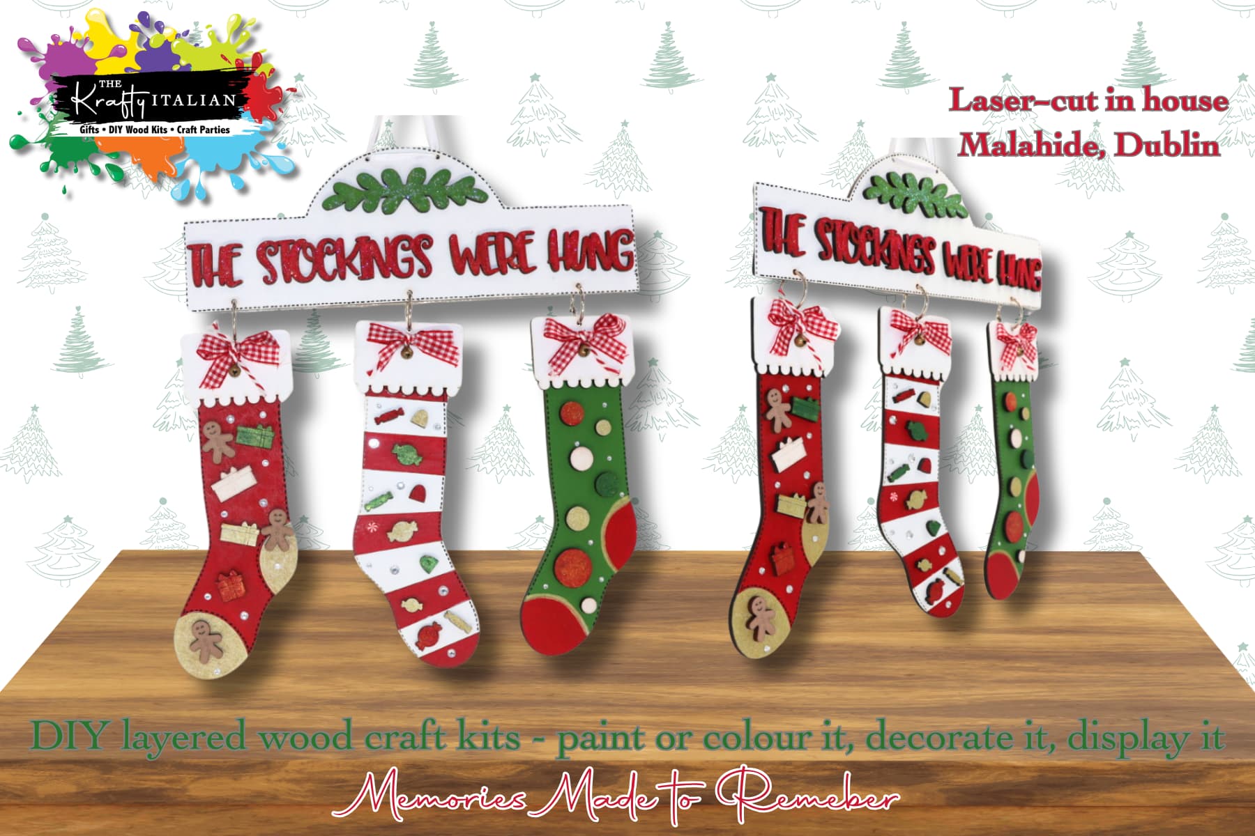 Two “The Stockings Were Hung Hanging Sign” DIY kits hang from labelled mantel signs, creating a charming shelf sitter display. Each kit includes three festive stockings ready to be decorated. The text highlights that they’re laser-cut in Malahide, Dublin—ideal for painting or colouring. The background features subtle tree graphics, bringing seasonal cheer reminiscent of Halloween sweet basket fun.
